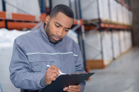 warehouse worker writing an investigationの写真素材