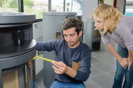Man measuring woodburner on display