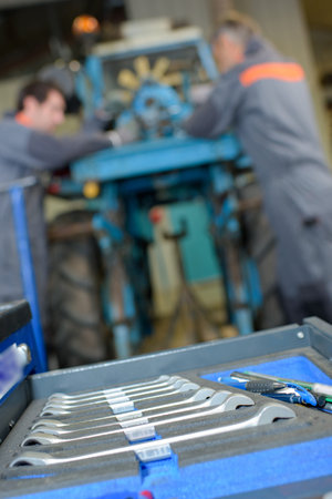 Closeup of set of spanners, mechanics in background