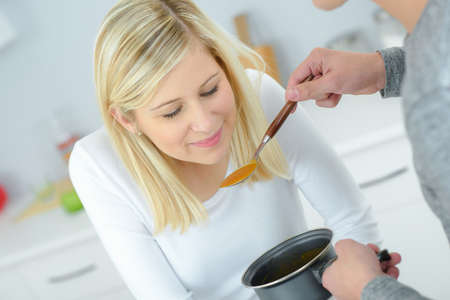 man making his fiance tasting his mealの写真素材