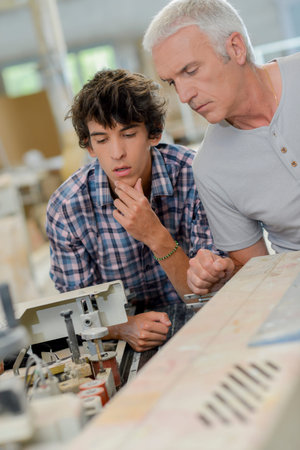 Carpenter working with apprenticeの写真素材
