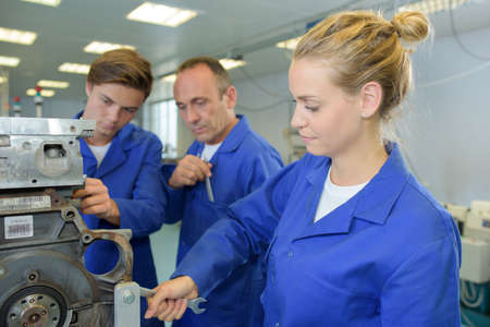 Woman adjusting machine with spannerの写真素材