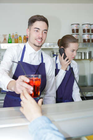 waitress and waiter working in barの写真素材