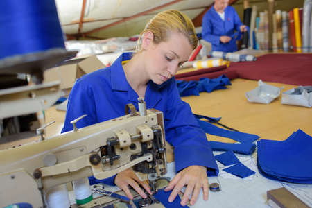 Woman using industrial sewing machineの写真素材