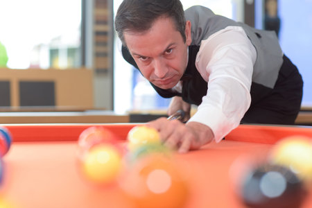 young professional man playing billard in the club