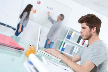 teen studying and writing notes on laptop at school