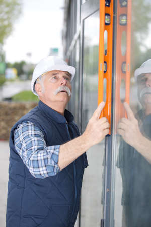 portrait of senior constructor holding a levelの写真素材