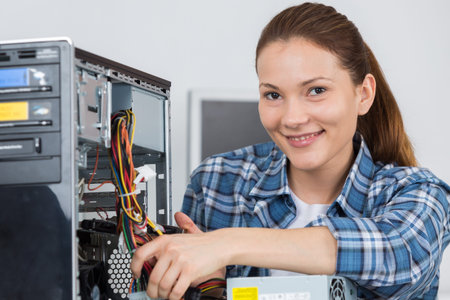 portrait of a female technician fixing computer with her colleagueの写真素材