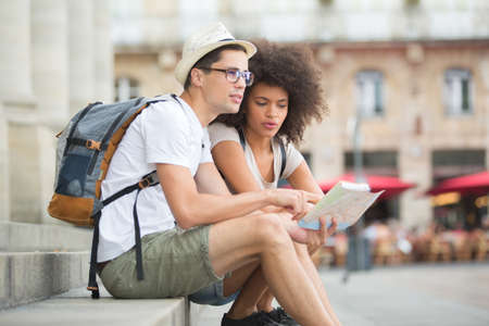 young couple of tourists visiting bordeaux and checking mapの写真素材