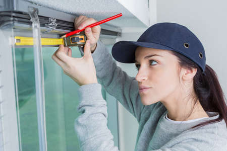 Woman using tape measure and marking positionの写真素材