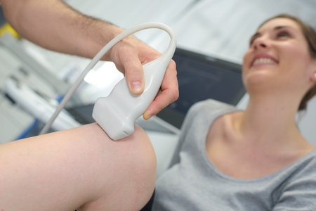 physiotherapist doctor performs treatment on a patients leg