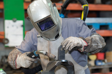 man with welding helmet welding steel