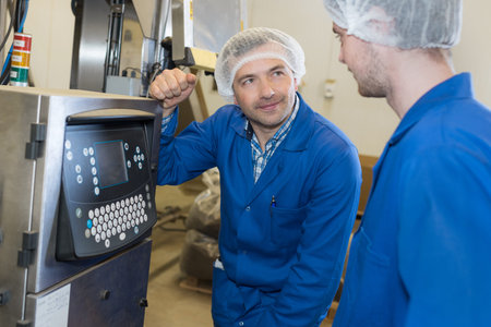 female apprentice working with engineer on cnc machinery