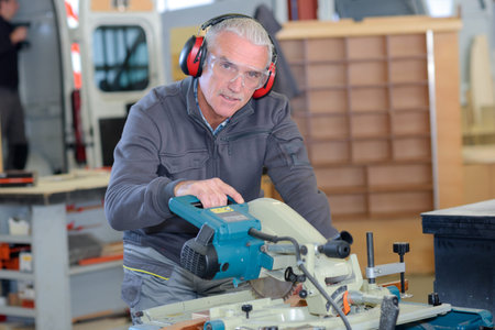 old-man man using a machine in a workshop