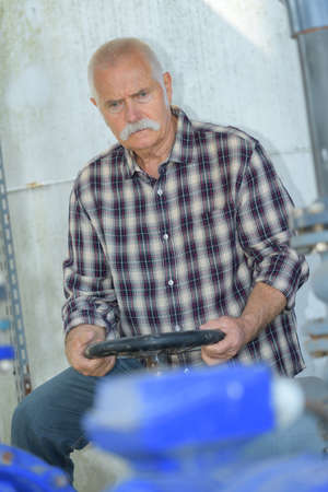 old man driving tractor indoorsの写真素材