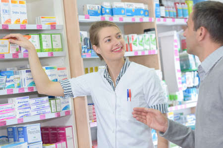 professional pharmacist helping a customerの写真素材