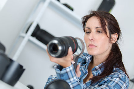 photographer checking a lens with a magnifying glass