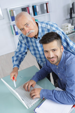 happy business partners or co-worker behind a desktop computer