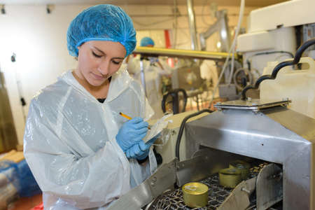 Female factory operative watching production lineの写真素材