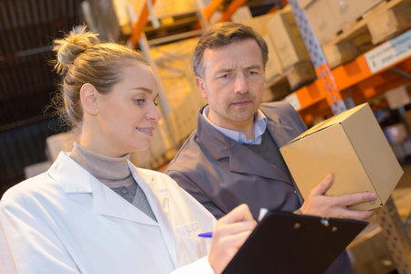 warehouse female worker in uniform checking cardboxes