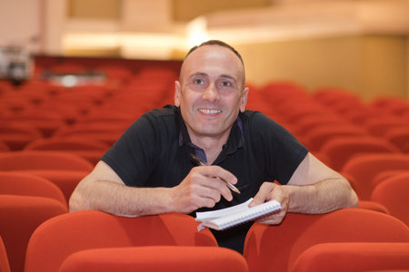 journalist standing near a film projector in the room projectionist