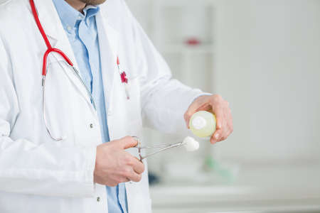a medical doctor disinfecting pliers at the hospitalの写真素材