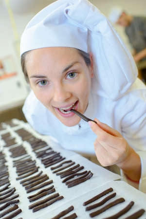 Chef eating chocolate sticksの写真素材