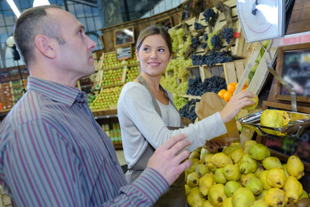 Shop assistant weighing lemons