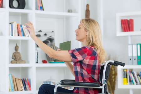 Disabled woman reaching book from shelf