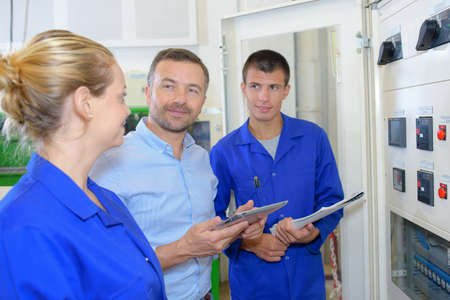 Man holding tablet with two young peopleの写真素材