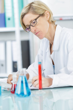 female scientist writing report on science experiments