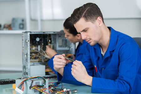 team of students examining and repairing computer parts