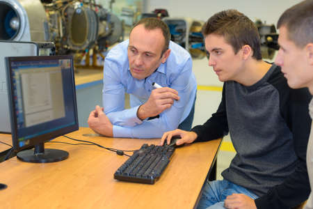 Students using computer, tutor supervisingの写真素材
