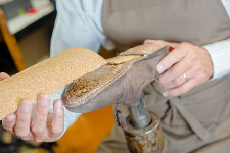 Cobbler restoring worn shoeの写真素材