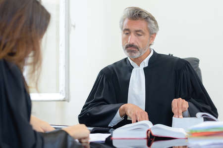 Male judge conferring with colleagueの写真素材