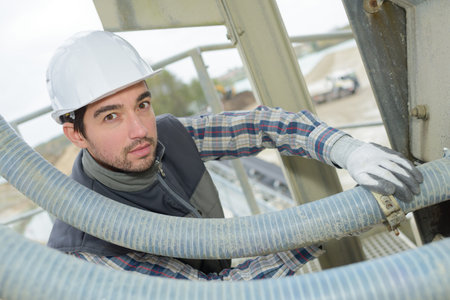 Man fitting jubilee clip on flexible pipe