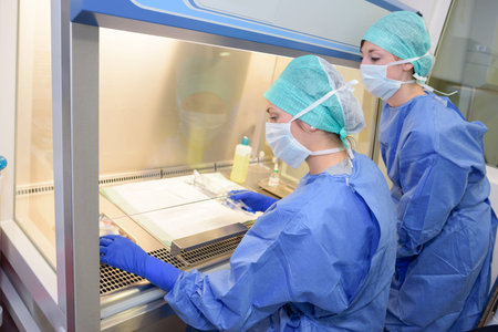 Lab technicians working behind sheet of glass