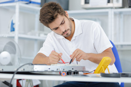 handsome electrician testing induction hobs