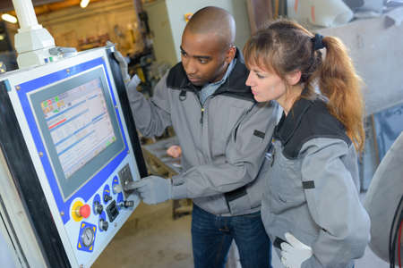 Industrial workers programming machineの写真素材