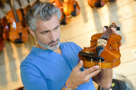 Man inspecting violin