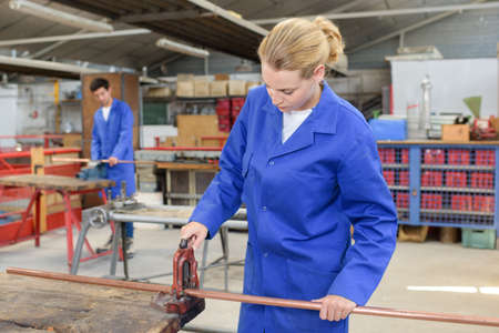 woman cutting copper pipeの写真素材