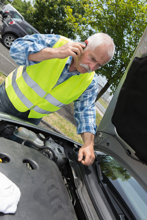 senior man seeking help to fix stalled vehicle