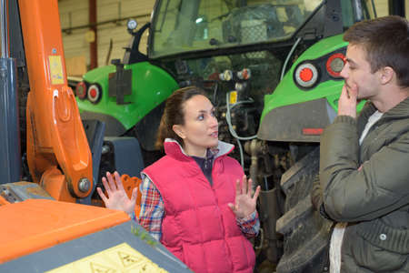 attractive woman selling brand new tractor to beginner farmerの写真素材