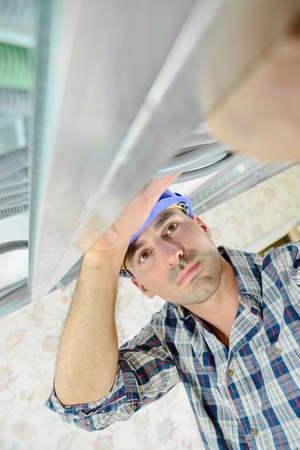Builder holding metal framework above his headの写真素材