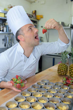 pastry chef holding delicious looking cakes and pastriesの写真素材