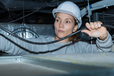 woman electrician checking a wire