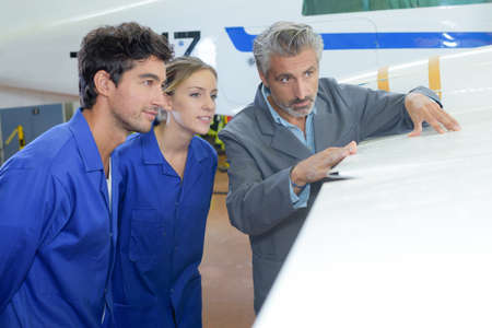 Two young people being shown wing of aircraftの写真素材