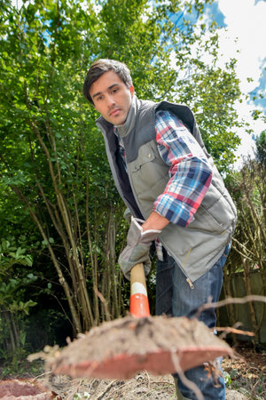 Gardener shovelling dirt