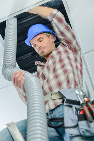 worker doing the ventilation systemの写真素材