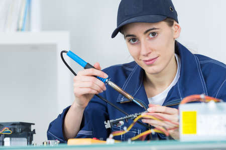 Female technician using soldering ironの写真素材